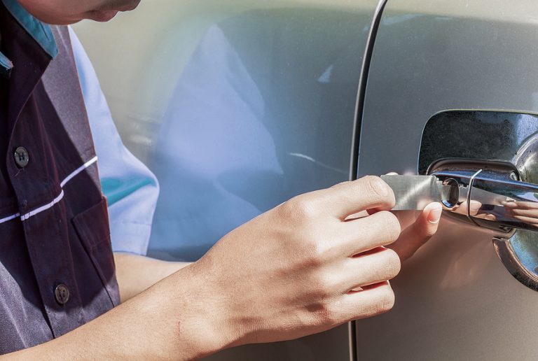 Close-up Of Person's Young Man Locksmith Hand Opening Bronze Car